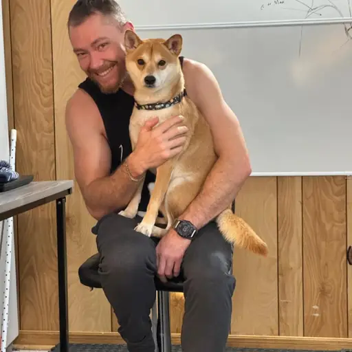 Corey Forrester smiling with Crash, his Shiba Inu